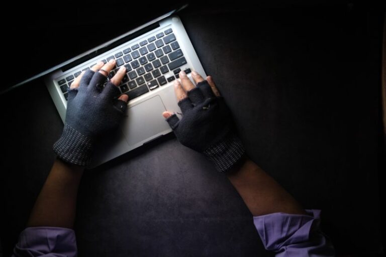 Hacker in a dark room using a laptop.